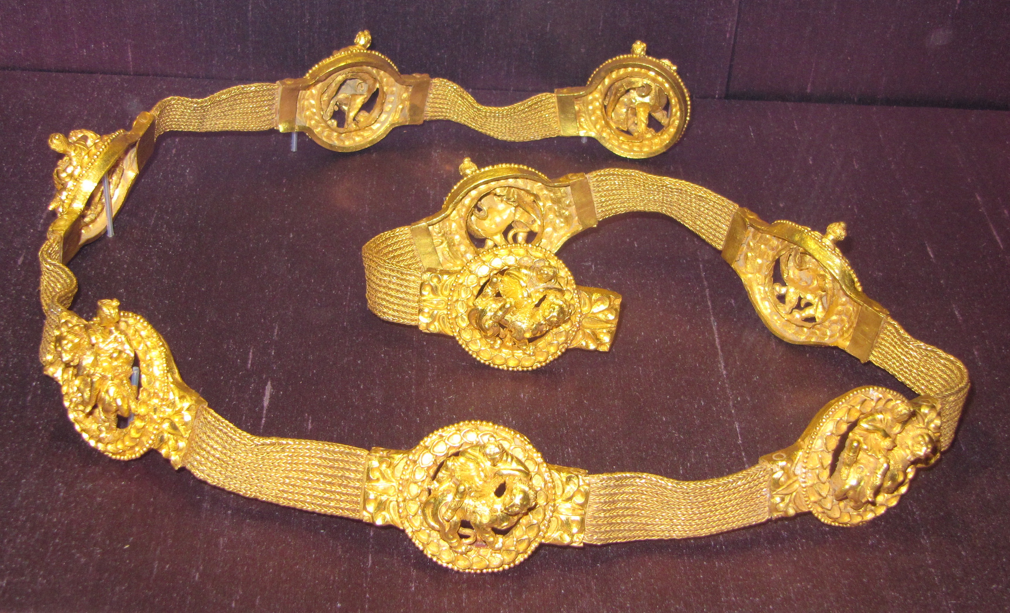 a gold belt with a series of medallions depicting women riding on lions a gold belt with a series of medallions depicting women riding on lions