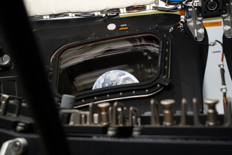 a bit of Earth is visible through the quadrangular window